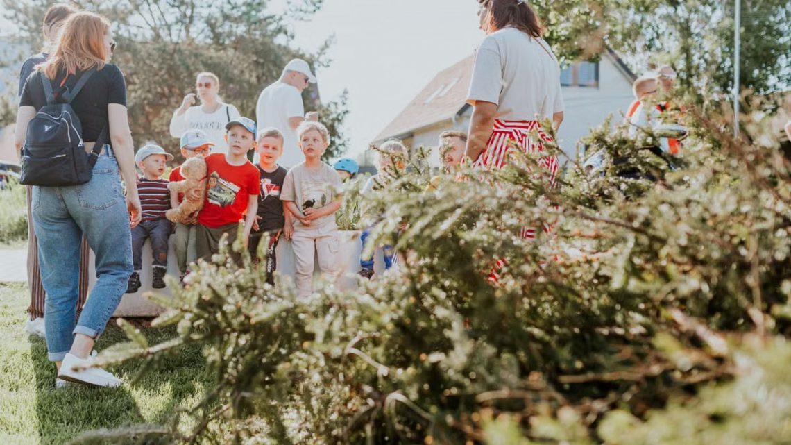 Children and adults participating in an outdoor educational activity surrounded by nature.